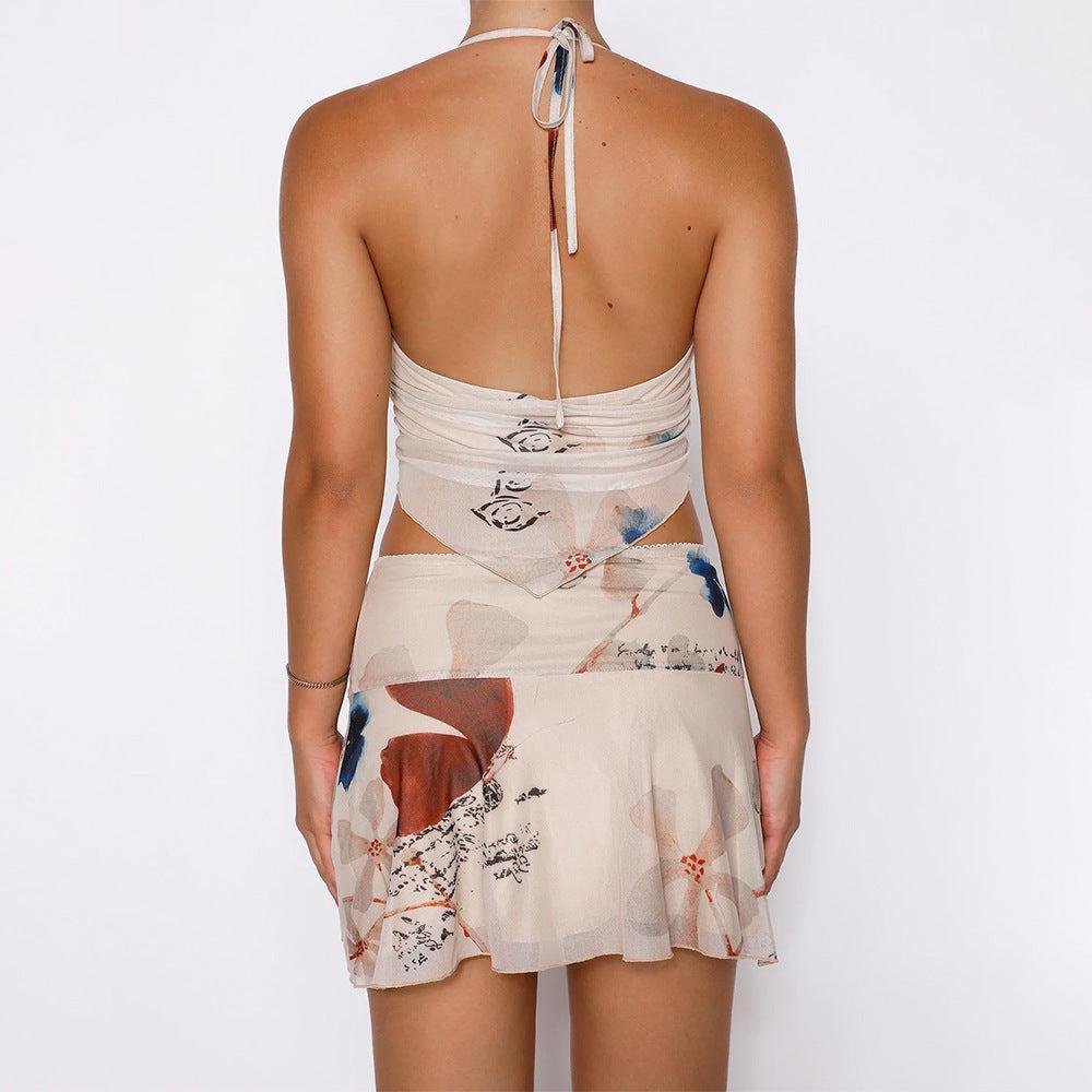 Woman wearing a red and white jacquard mini dress with floral patterns and side cutouts, posing on pink stairs in a summer setting.